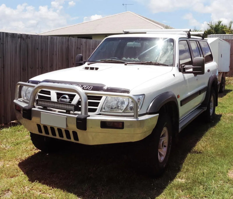 White Nissan Patrol GU Y61 SUV with bull bar and roof rack featuring extendable towing mirrors