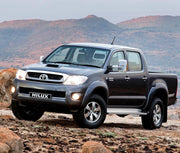 Toyota Hilux with towing mirrors and headlights on, showcasing extendable towing mirrors