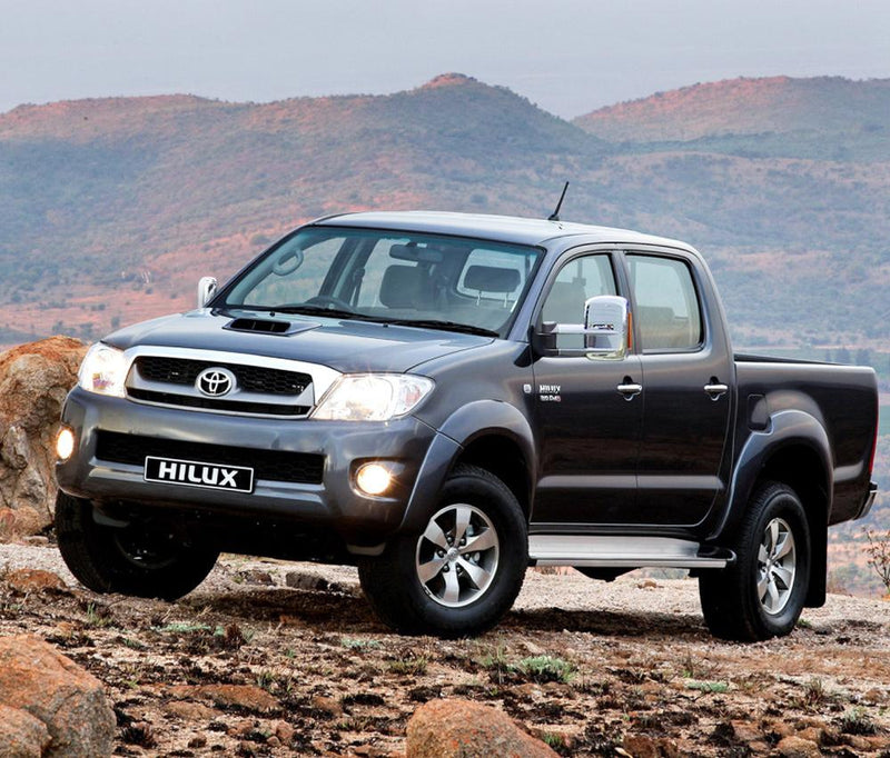 Toyota Hilux with towing mirrors and headlights on, showcasing extendable towing mirrors