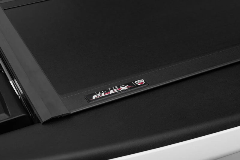 Black electronic device corner with AMD logo on ultra flex hard folding truck bed cover