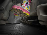 Colorful rain boot with muddy sole on WeatherTech FloorLiner for vehicle floor protection