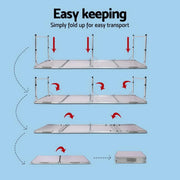 Foldable camping table with collapsible metal poles and flat surface for portable camping use